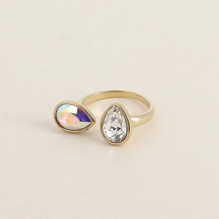 Kullanvärinen säädettävä Bohm Paris -sormus kahdella pisaranmuotoisella Swarovski-kristallilla, joista toinen on kirkas ja toinen sateenkaarenväärinen Aurora Borealis."