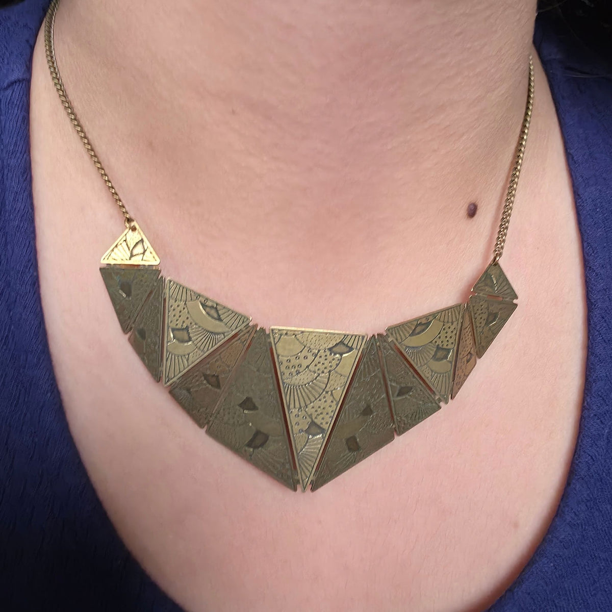 Pronssinvärinen Amélie Blaise Origami kaulakoru puettuna kaulaan. Graafinen ja taiteellinen ranskalainen statement-kaulakoru Solessa verkkokaupasta.