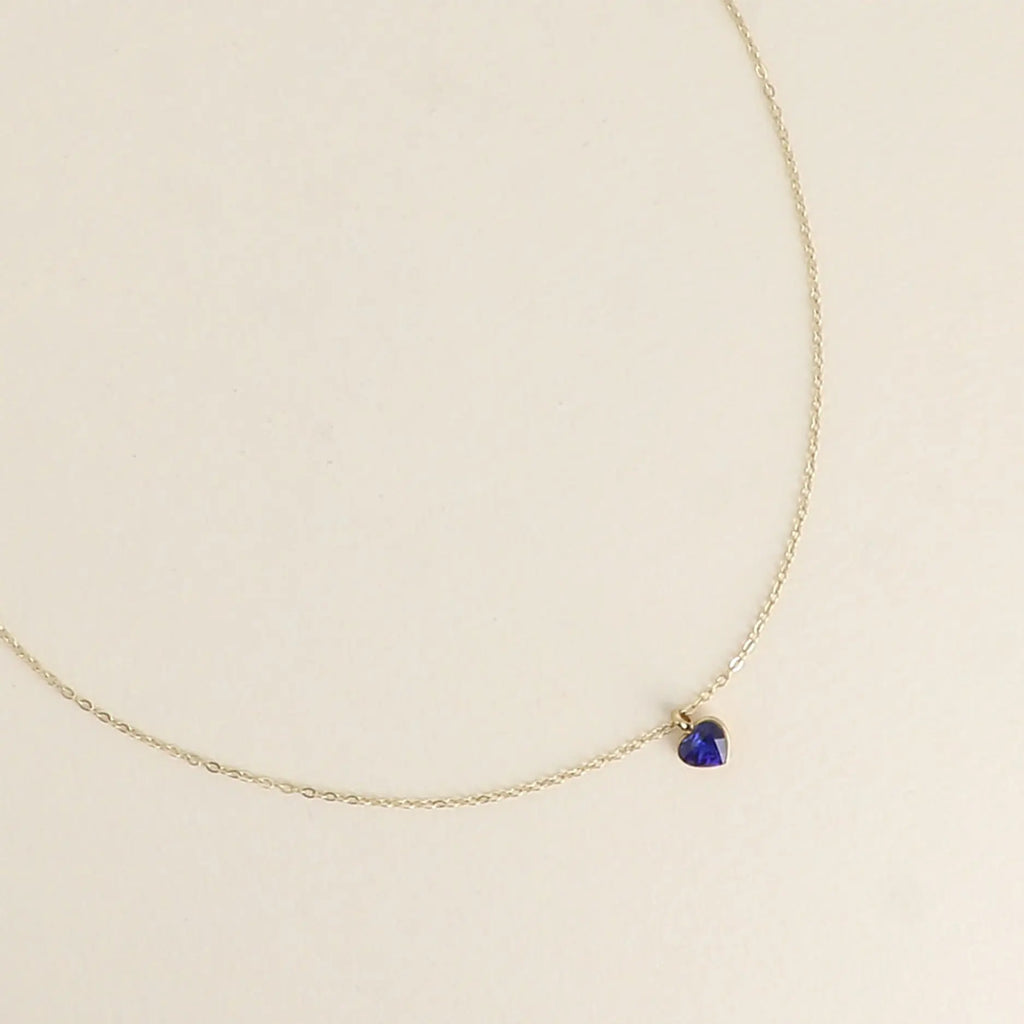 Siro kullanvärinen kirurginteräksinen Bohm Paris -kaulakoru, jossa on pieni safiirinsininen sydämenmuotoinen Swarovski-kristalliriipus.