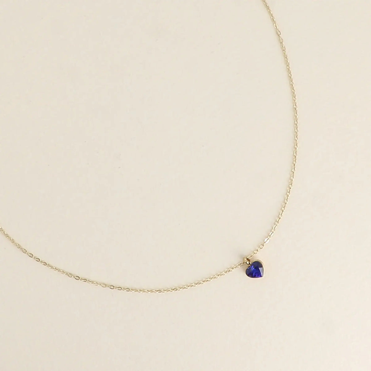 Siro kullanvärinen kirurginteräksinen Bohm Paris -kaulakoru, jossa on pieni safiirinsininen sydämenmuotoinen Swarovski-kristalliriipus.