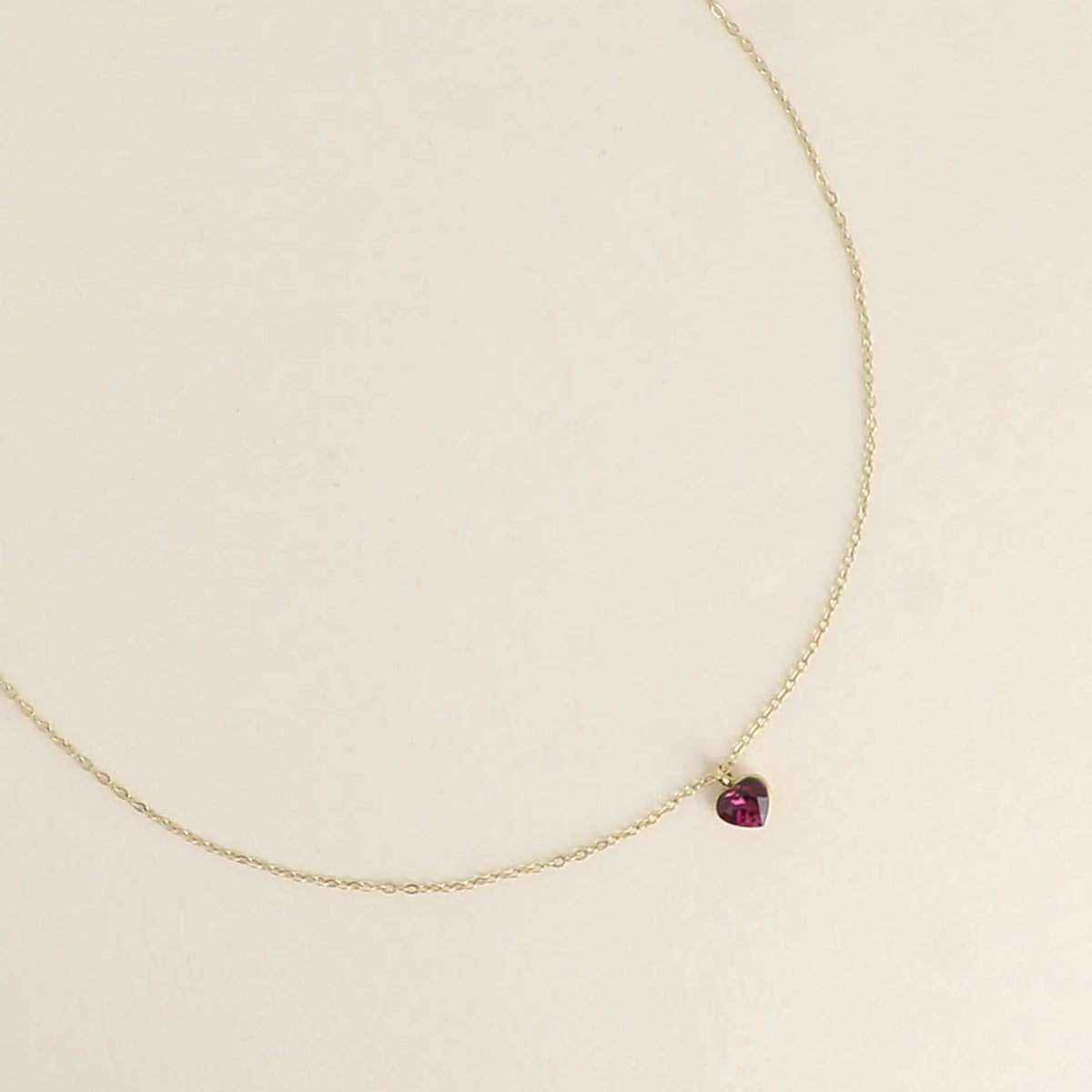 Siro kullanvärinen kirurginteräksinen Bohm Paris -kaulakoru, jossa on pieni viininpunainen sydämenmuotoinen Siam Swarovski-kristalliriipus.