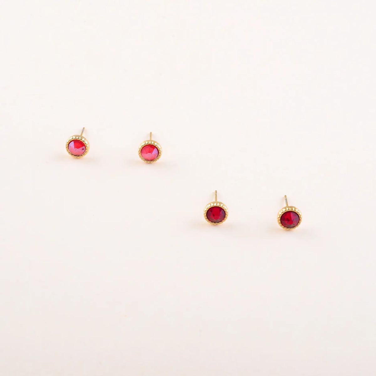 Bohm Paris Maelia kahden parin kullanvärinen kristallikorvakorusetti, jossa on kuvioitu kranssireunus, viininpunaiset Royal Red ja fuksianpunaiset Fuchsia Swarovski-kristallit.
