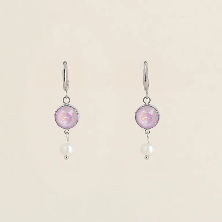 Sirot hopeanväriset rengaskorvakorut, joissa roikkuu pyöreä lila Swarovski-kristalli ja sen alapuolella pieni valkoinen makeanvedenhelmi.