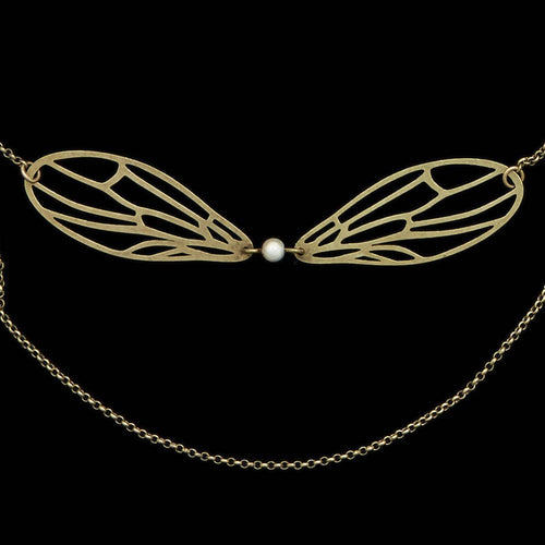 Lähikuva Amélie Blaise Dragonfly White Pearl -kaulakorusta, jossa on pronssiset sudenkorennon siivet ja keskellä valkoinen helmi kaksirivisessä ketjussa.