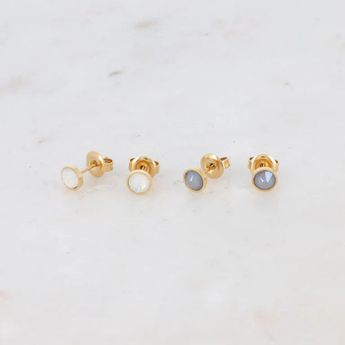 Bohm Paris Ally korvakorusetti, joka sisältää vaaleat helmiäishohtoiset ja harmaat pyöreät Swarovski kristallinapit kullanvärisellä kirurginteräsrungolla.